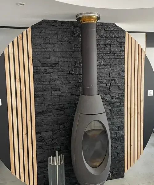 pierre de parement derrière poêle à bois par Peintures Richard à Vauvert